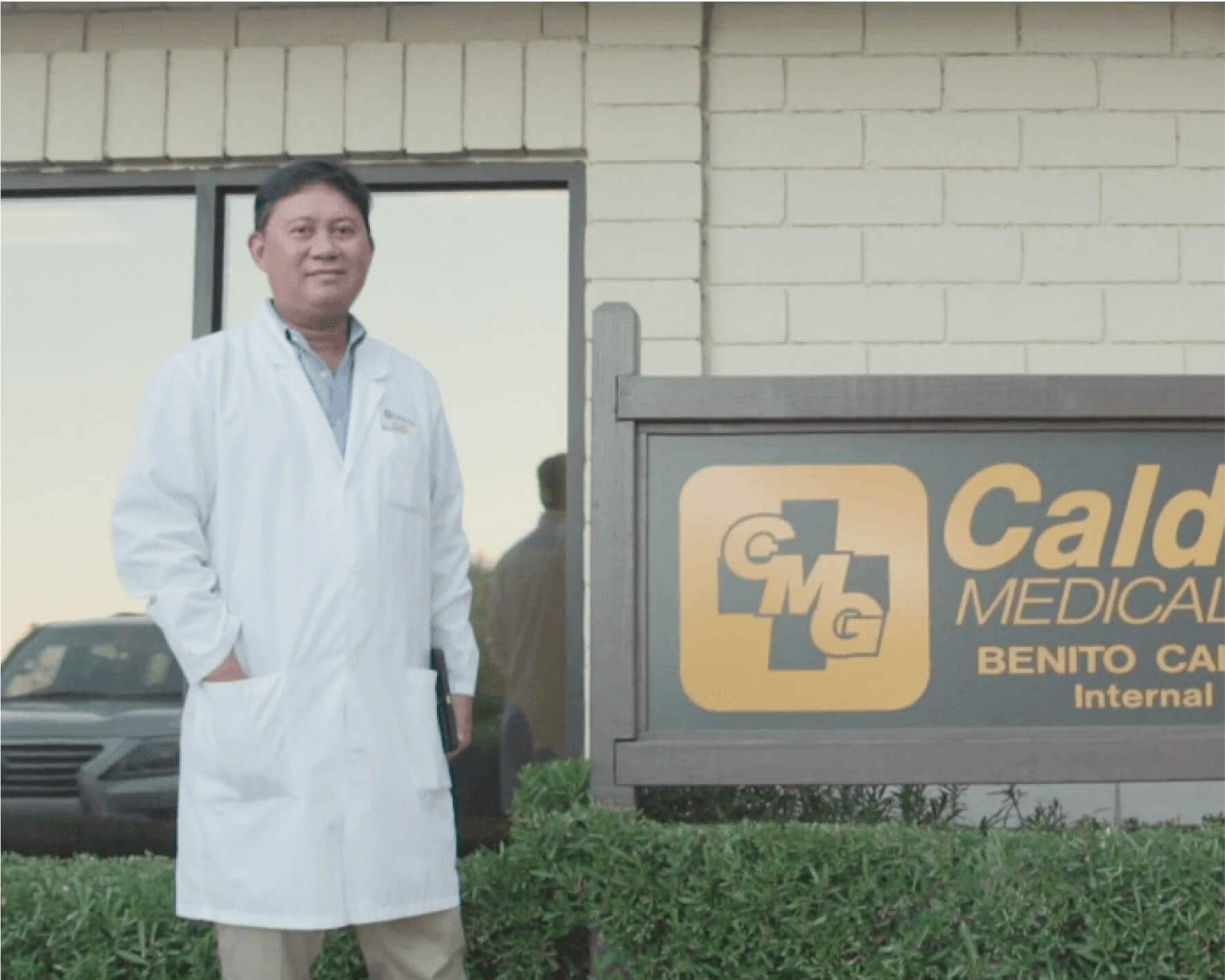 Benito Calderon from Calderon Medical Group stands outside his rooms beside a large signboard for the practice.