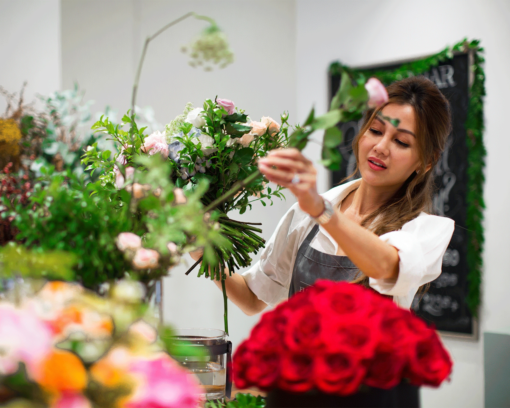 Business owner Lelian arranging flowers in her store. She imports transactions into Xero.