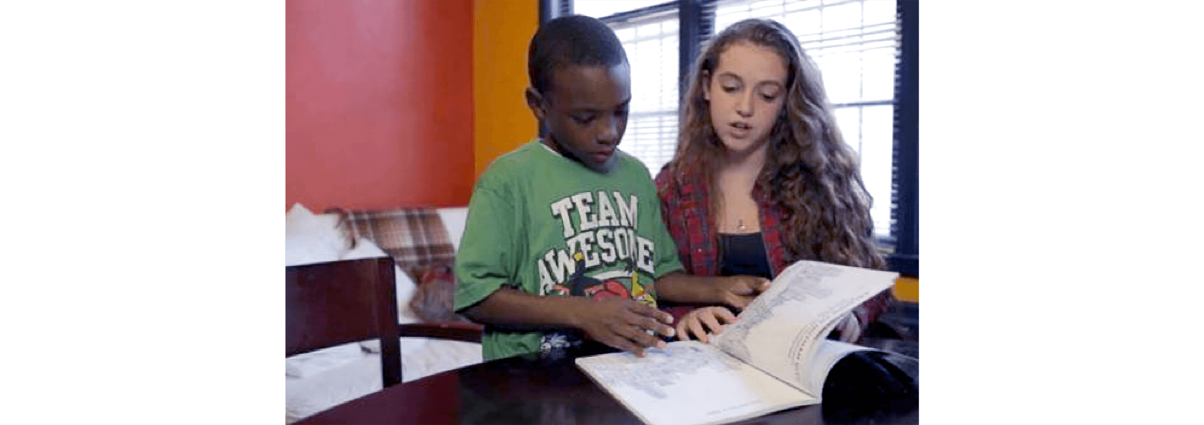 Two children reading a book together.