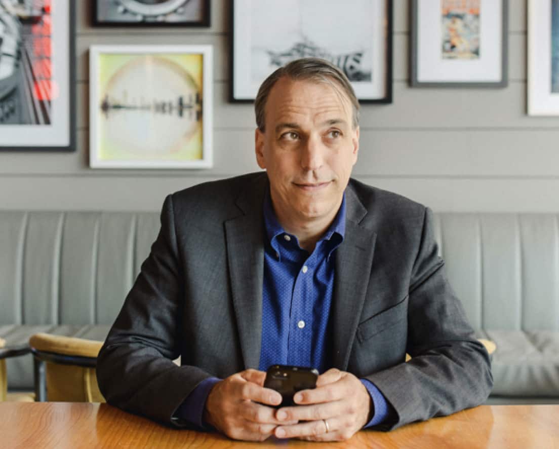 John DeLalio sits at a table, discussing Xero accounting software.